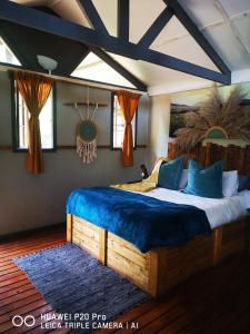 MoremelaTreur River Lodge的一间卧室配有一张带蓝色毯子的大床