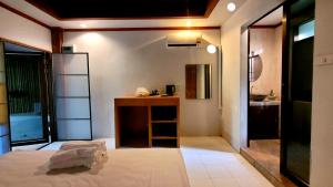 西塔努Cassiopeia Srithanu Apartments的客房设有一张床和一间带水槽的浴室