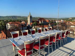 赛比什鲁尔德奥尔酒店的阳台上配有一张长桌子和红白椅子