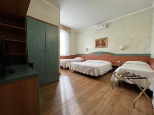 比萨普利莫沃勒别墅酒店的客房设有两张床和一台平面电视。