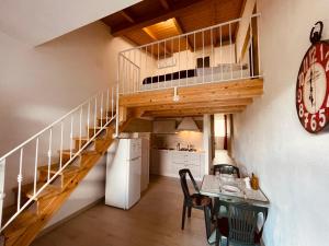 Cala SaponeCamping Tonnara的一间厨房和带螺旋楼梯的用餐室,位于一栋房子内