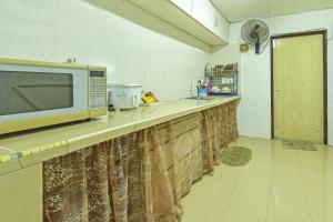 Kampong Sungai MatiOYO HOME 90692 Tok Babah Village Homestay的厨房的台面上有一个微波炉