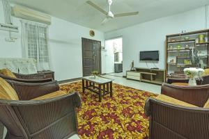 Kampong Sungai MatiOYO HOME 90692 Tok Babah Village Homestay的客厅配有椅子和平面电视