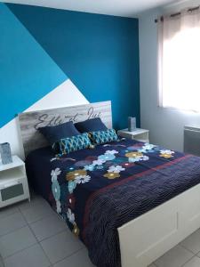 乌尔坦Maison chaleureuse lac & mer的一间卧室配有一张蓝色墙壁的床