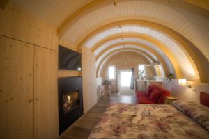 蒙泰克雷托Glamping Villaggio Parco Dei Castagni 4 stelle的一间卧室设有一张大床和一个壁炉