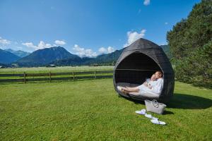 奥伯斯特多夫舒尔康体SPA度假酒店 - 仅限成年人的一对夫妇躺在草地上的冰屋里