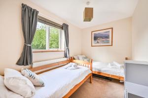 特鲁罗3 bed Lodge with EV point的一间卧室设有两张床和窗户。