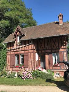 Maison de gardien , manoir de Pichemont, » la maison des écureuils »的前面有鲜花的小砖房子