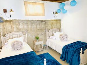 BuzanadaAlisios HOT TUB sauna piscina y naturaleza的蓝色和白色的客房内的两张床