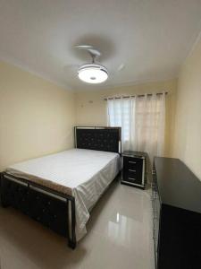 MendozaThree bedroom, two bath flat in San Isidro, Santo Domingo Este的一间卧室配有一张床、一张桌子和一个窗户。