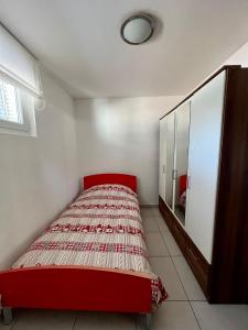 Morbio InferioreAppartamento vacanze Sanzen - Como Cernobbio Lugano的一间卧室配有红色的床和镜子