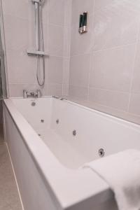 利物浦Phoenix Hotel Liverpool的带淋浴的浴室配有白色浴缸。