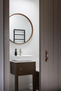 斯坦福德Linseed Barn- Stamford Holiday Cottages的浴室设有水槽和墙上的镜子