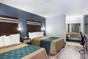 哈蒙顿Red Carpet Inn & Suites NJ-73的酒店客房设有两张床和电视。