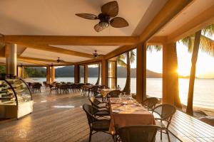象岛龙海景别墅 的海滩上的餐厅,配有桌椅