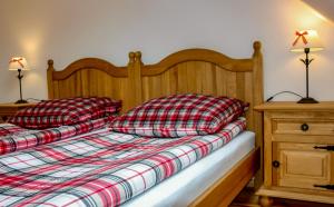 Paszowice兰花山农家乐的一张带红白色床单的床和两个枕头