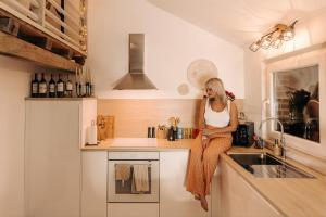 Hastière-par-delàLa Love Story的坐在厨房柜台上的一个女人在手机上讲话