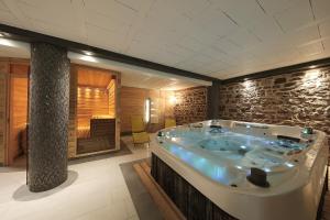 OsenbachLe Domaine du Verger, Chambres et SPA prive的石墙客房内的按摩浴缸