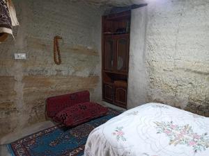 于尔居普CAVE HOUSE(KIR EVİ)的一间卧室,卧室内配有一张床和一把椅子