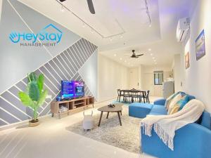 马六甲OngKimWee Residence By Heystay Management的客厅配有蓝色的沙发和电视