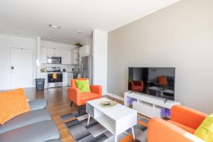 印第安纳波利斯Affordable 1BD, Comfy Queen Beds, with GYM的客厅配有橙色椅子和白色桌子