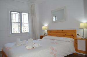 安波拉Casa Mar i Sol的一间卧室配有两张带白色床单的床和两个窗户。