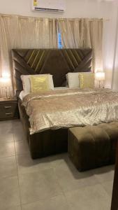阿克拉Accra Luxury apartments at Oasis Park Residences的卧室内的一张大床,配有两盏灯