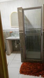 里奥阿托Sunrise Hostel Farallon的带淋浴、水槽和地毯的浴室