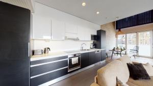 卡拉约基Sandy Kelt - Irish House Apartments的一间厨房,配有黑白橱柜和一间客厅