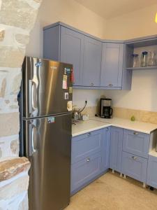 帕罗斯岛Villa Laugh, on The Limnes Beach的厨房配有蓝色橱柜和不锈钢冰箱