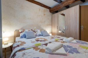 斯维蒂皮塔乌苏米Apartman Vrh的一间卧室配有一张带花卉床罩的大床