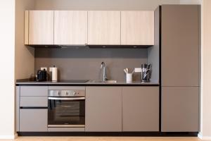 米兰Daplace - Portaluppi Apartment的厨房配有白色橱柜、水槽和炉灶。