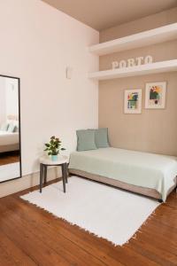 波尔图山度家公寓酒店的一间卧室配有一张床、一张桌子和一面镜子