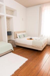 波尔图山度家公寓酒店的一间铺有木地板的白色卧室,配有一张床