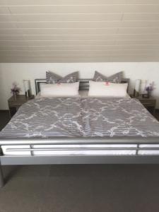 达勒姆乌尔里希旅馆的卧室配有一张大床,提供灰色床单和枕头