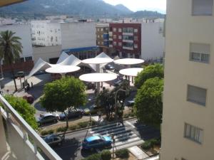 奥利瓦橙花酒店的享有停车场的顶部景色,配有白色遮阳伞