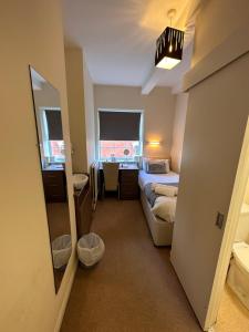 曼斯菲尔德281 Hotel & Restaurant的一间卧室配有床、水槽和镜子