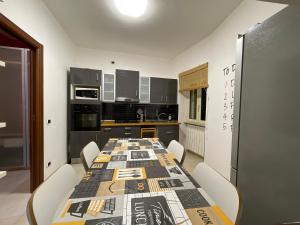 CeccanoIl Torrione的厨房配有长桌子、白色椅子和餐桌糕点