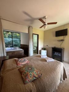 马卡科斯Macaco Prosa的一间卧室配有一张带吊扇的床和一个浴缸