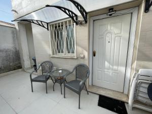 菲乌米奇诺TheMaki'sHouse的一个带桌椅的庭院和一扇白色门