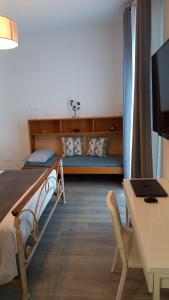 勒托阳尼Le Spiagge的一间卧室配有一张床和一张带笔记本电脑的书桌