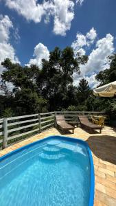 马卡科斯Sensorial Macacos的木制围栏旁的大型蓝色游泳池