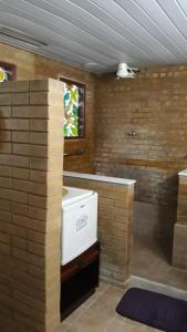 PapucaiaHotel Fazenda Terra Ramos的浴室设有砖墙和白色的电器