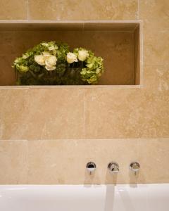 杜伦40Winks的浴室水槽设有两个水龙头和植物
