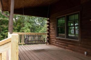 米勒斯堡Maple Leaf Cabin的小木屋的门廊上设有长凳