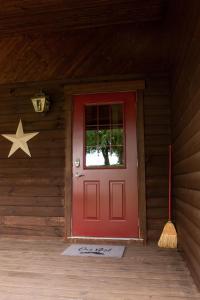 米勒斯堡Maple Leaf Cabin的木房子里一扇红色的门,墙上有一星星