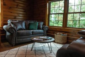米勒斯堡Maple Leaf Cabin的客厅配有真皮沙发和桌子
