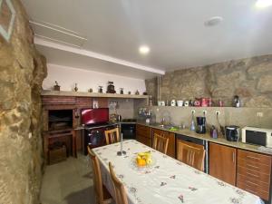 Casa dos Telhados的厨房配有桌子和石墙
