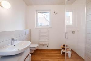 HoisdorfAm Thie的白色的浴室设有水槽和卫生间。