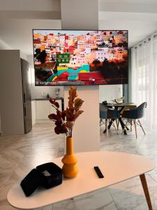 雅典Casa de Tres Hermanos in the heart of Athens的客厅配有桌子和墙上的电视